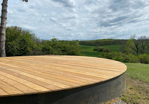 Terrasse en bois avec une forme arrondie, réalisée avec une structure durable pour un design harmonieux.