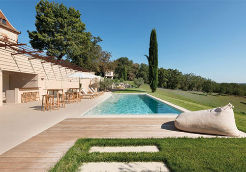 "Terrasse haut de gamme en bord de piscine, combinant bois et céramique pour un rendu moderne et durable.