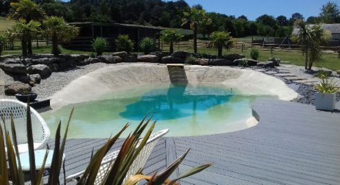 Terrasse en bois composite entourant une piscine, illustrant une solution durable et esthétique pour les espaces extérieurs.